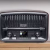 Una foto d'ambiente che mostra la radio M-135 DBT posizionata su un ripiano in cucina, con una tazza di caffè accanto. Il display è acceso su una stazione DAB+, comunicando calore, quotidianità e modernità.