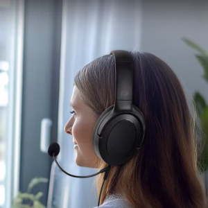 Una persona in un ufficio domestico indossa le cuffie Muse M-212 CH mentre partecipa a una videoconferenza sul suo laptop, con un'espressione professionale e concentrata."