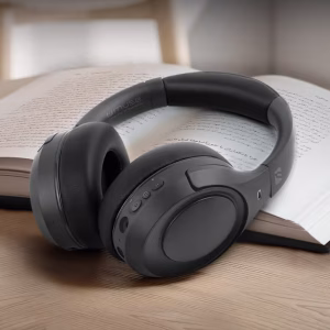 Le cuffie M-295 ANC sono mostrate ripiegate e inserite a metà nella loro custodia da viaggio nera con zip, accanto a un passaporto e un libro, per sottolinearne la vocazione da viaggio."