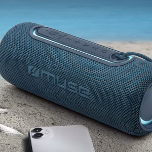 o speaker M-780 BTB su un tavolo a bordo piscina con alcune gocce d'acqua sulla superficie in tessuto, a dimostrazione visiva della sua resistenza agli spruzzi IPX4."