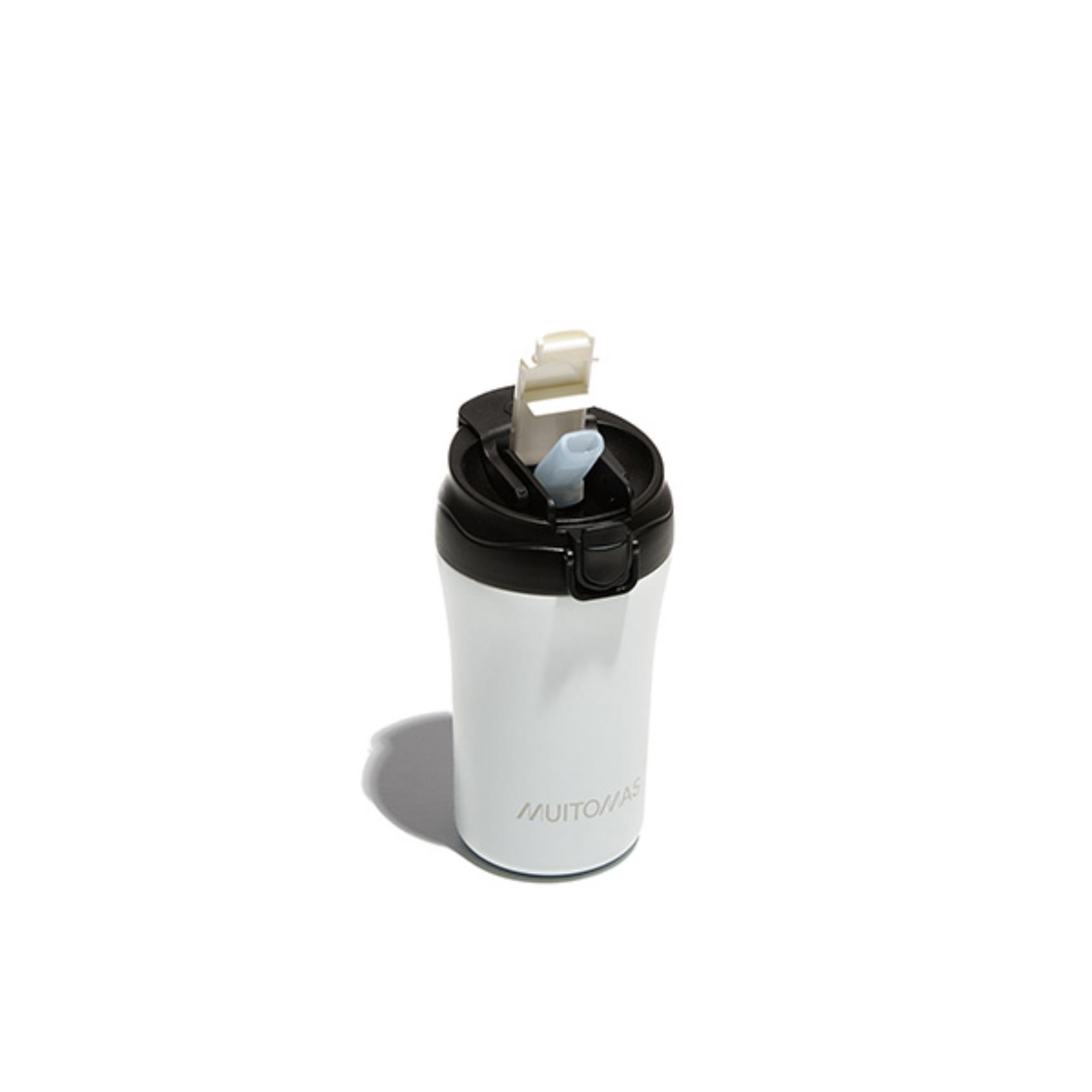 La tazza termica da viaggio MUITOMAS da 350ml nel colore BIANCO, con il suo tappo "flip" chiuso e la sua elegante fascia in silicone. La tazza termica da viaggio MUITOMAS da 350ml nel colore BIANCO, con il suo tappo "flip" chiuso e la sua elegante fascia in silicone.