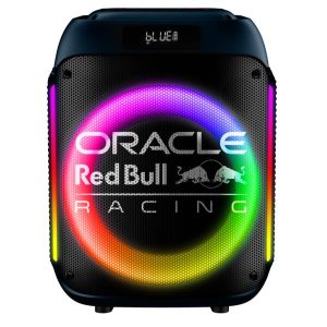 Foto a figura intera dello Speaker Wireless Red Bull 40W (Boombox) con le luci LED multicolore attive, posizionato su un tavolo da esterno. Si notano la griglia in acciaio, la maniglia di trasporto e il logo ufficiale Red Bull Racing. Immagine ottimale per la keyword "Speaker Bluetooth da festa con luci LED".